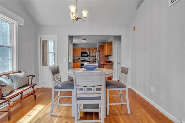 57 Center St, Dartmouth, MA 02748 - dining area with light wood-style floors, a chandelier, and baseboards