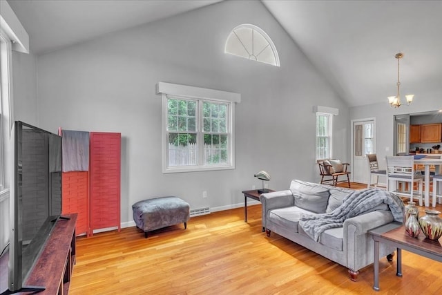 57 Center St, Dartmouth, MA 02748 - living room featuring high vaulted ceiling, a chandelier, light wood-type flooring, baseboards, and a fireplace