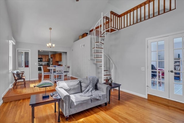 57 Center St, Dartmouth, MA 02748 - living room featuring stairs, high vaulted ceiling, baseboards, light wood-style floors, and a chandelier