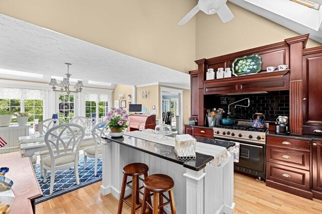 39 High Beacon Way, Marshfield, MA 02050 - kitchen with gas range, light wood-style floors, dark countertops, and high vaulted ceiling