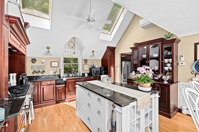 39 High Beacon Way, Marshfield, MA 02050 - kitchen with a skylight, stainless steel refrigerator with ice dispenser, a ceiling fan, dark countertops, and a kitchen island