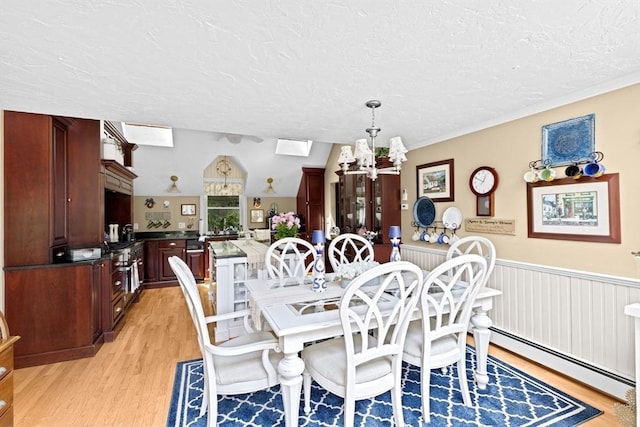 39 High Beacon Way, Marshfield, MA 02050 - dining area featuring light wood-style flooring, a baseboard radiator, a textured ceiling, and a chandelier