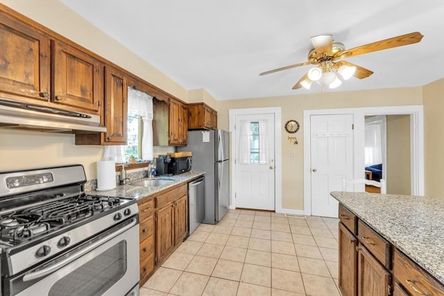 252 Railroad Ave, Norwood, MA 02062 - kitchen with appliances with stainless steel finishes, under cabinet range hood, brown cabinetry, a ceiling fan, and light tile patterned flooring