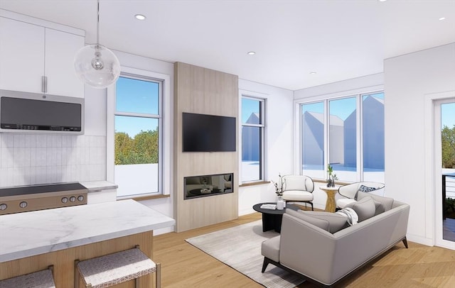 living area with recessed lighting, light wood-style floors, and a healthy amount of sunlight