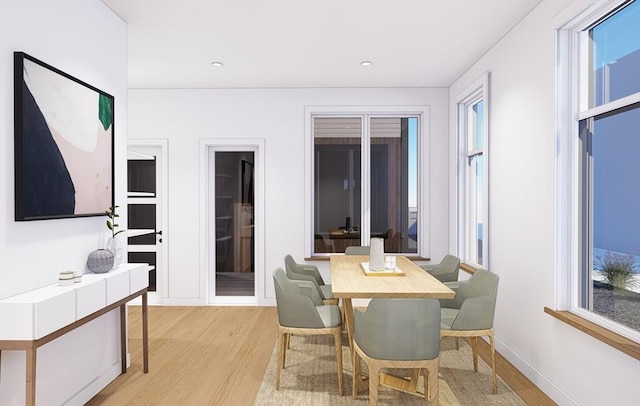 dining area with light wood finished floors, plenty of natural light, and baseboards