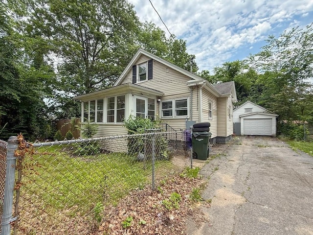 23 Eldert St, Springfield, MA 01109 - view of front facade featuring driveway, an outdoor structure, a garage, and a sunroom