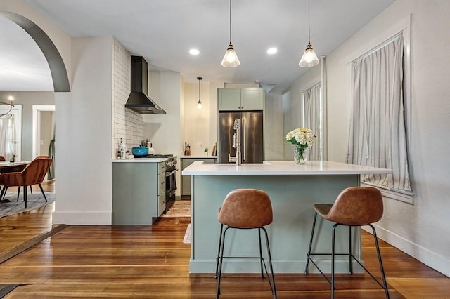 2 Oxford Pl, Worcester, MA 01609 - kitchen featuring wall chimney range hood, appliances with stainless steel finishes, baseboards, light countertops, and a breakfast bar