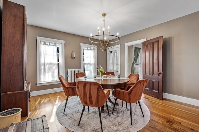 2 Oxford Pl, Worcester, MA 01609 - dining area with radiator heating unit, a chandelier, baseboards, and light wood-style floors