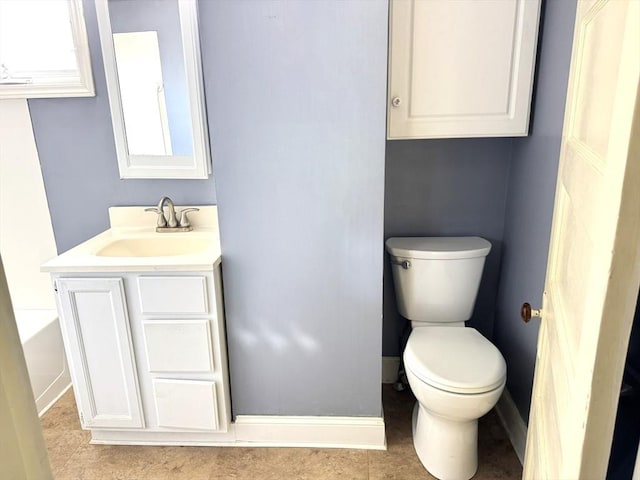 bathroom with vanity, baseboards, and toilet