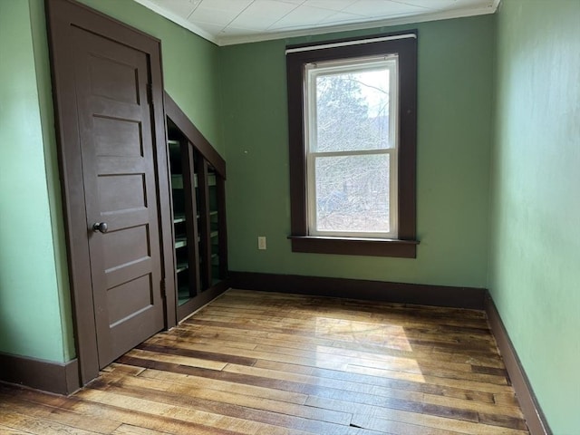 spare room featuring baseboards, ornamental molding, and hardwood / wood-style flooring