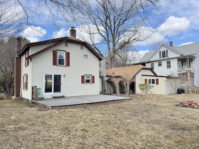 rear view of house featuring a wooden deck and a chimney