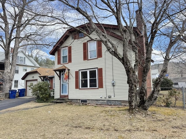 view of front of house with entry steps, fence, a chimney, a garage, and driveway