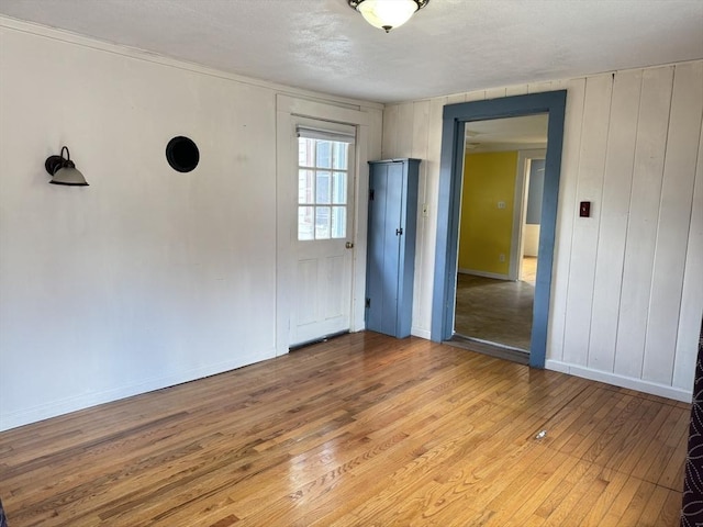 spare room featuring baseboards and light wood-style floors