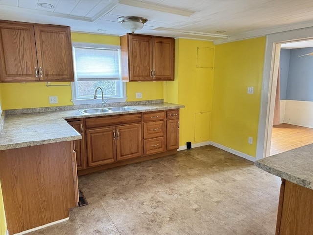 kitchen featuring a sink, light countertops, and brown cabinets