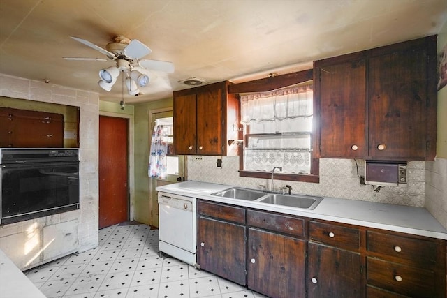 kitchen featuring dishwasher, sink, oven, and backsplash