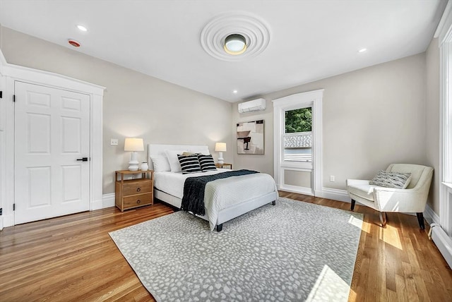 30 Forest Park Rd, Woburn, MA 01801 - bedroom featuring a wall mounted AC, light wood-type flooring, and a baseboard heating unit