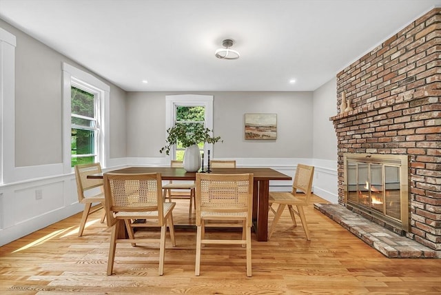 30 Forest Park Rd, Woburn, MA 01801 - dining room with light wood finished floors, a brick fireplace, a wainscoted wall, and a decorative wall