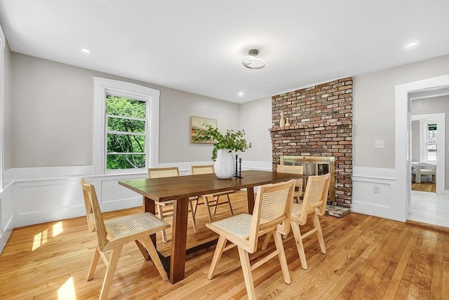 30 Forest Park Rd, Woburn, MA 01801 - dining area featuring light wood-style floors, a wainscoted wall, a brick fireplace, recessed lighting, and a decorative wall