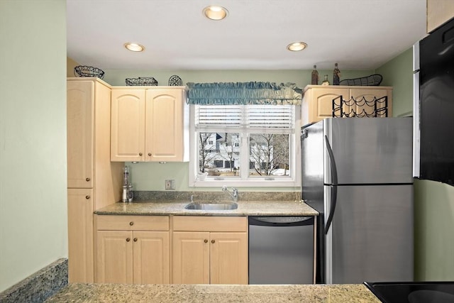 kitchen with stainless steel appliances, a sink, and light brown cabinetry