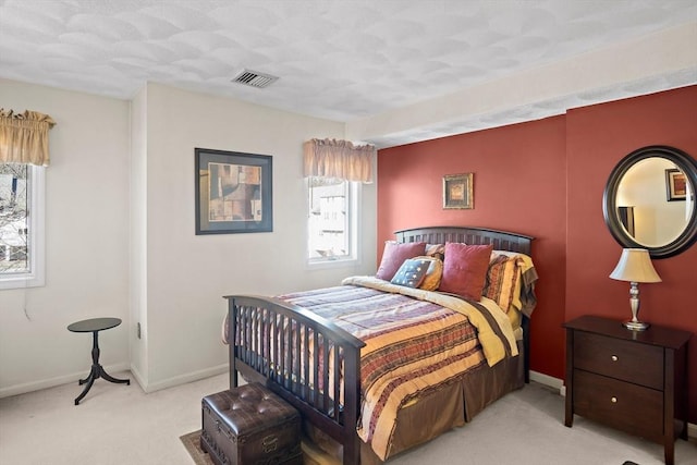 carpeted bedroom featuring baseboards and visible vents