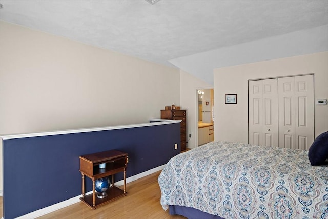 bedroom featuring a closet, baseboards, and wood finished floors