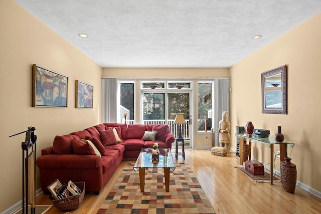 living room featuring light wood-style floors, baseboards, and recessed lighting