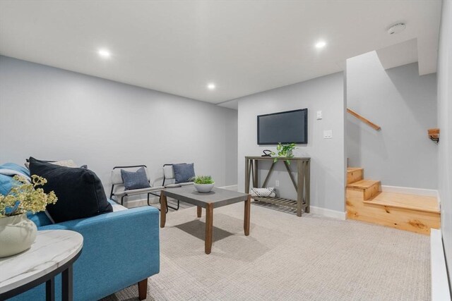 living area with recessed lighting, stairs, baseboards, and light colored carpet