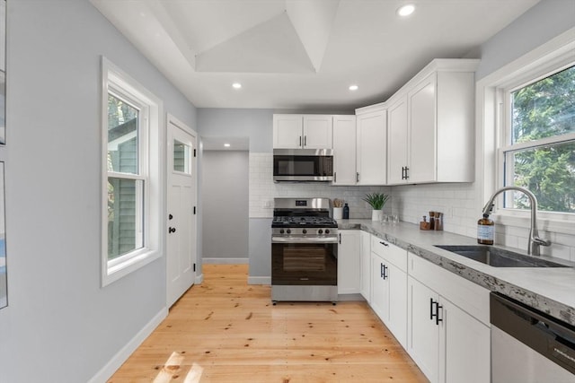 kitchen with stainless steel appliances, recessed lighting, decorative backsplash, and a sink