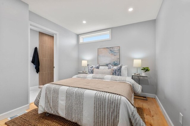 bedroom featuring baseboards, recessed lighting, wood finished floors, and visible vents