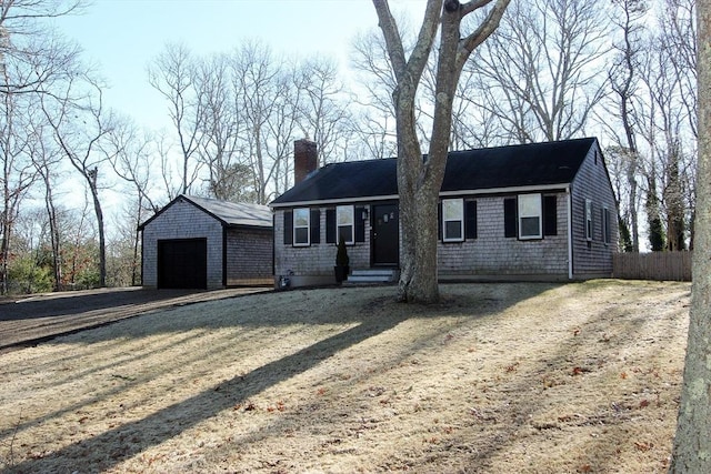 single story home featuring an outbuilding, a chimney, a detached garage, and fence