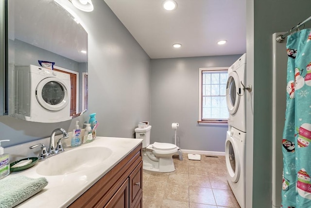 bathroom with a shower with curtain, tile patterned flooring, toilet, vanity, and stacked washer and clothes dryer