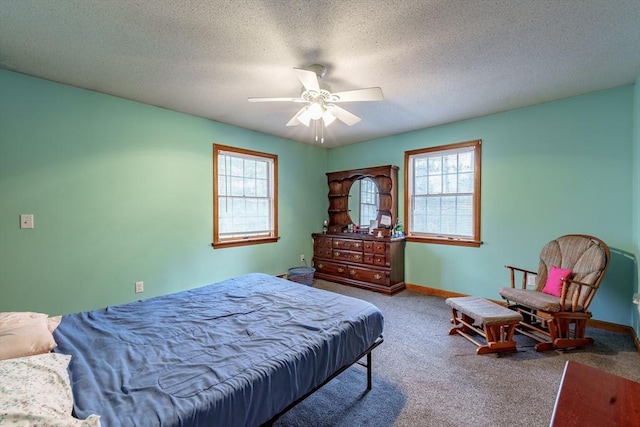 bedroom featuring ceiling fan, carpet floors, and a textured ceiling