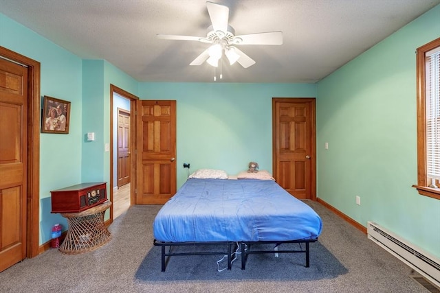 bedroom featuring ceiling fan, carpet floors, and a baseboard heating unit