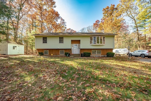 bi-level home with a front lawn and a storage unit