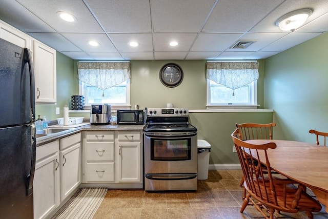 kitchen featuring a drop ceiling, white cabinets, black appliances, and sink