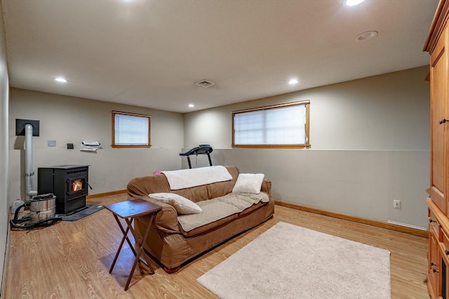 living room featuring light wood-type flooring and a wood stove