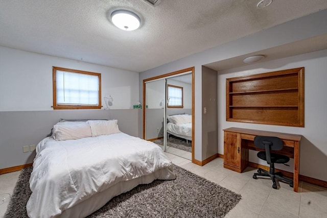 bedroom with multiple windows, a textured ceiling, and a closet