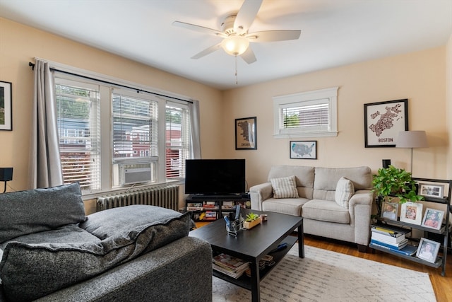 living room with light hardwood / wood-style floors, cooling unit, radiator heating unit, and ceiling fan