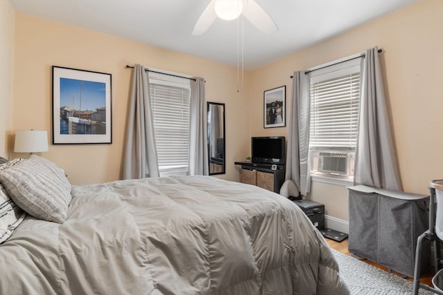 bedroom featuring hardwood / wood-style floors, cooling unit, and ceiling fan