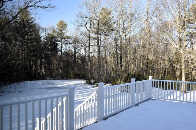 snowy yard featuring a forest view