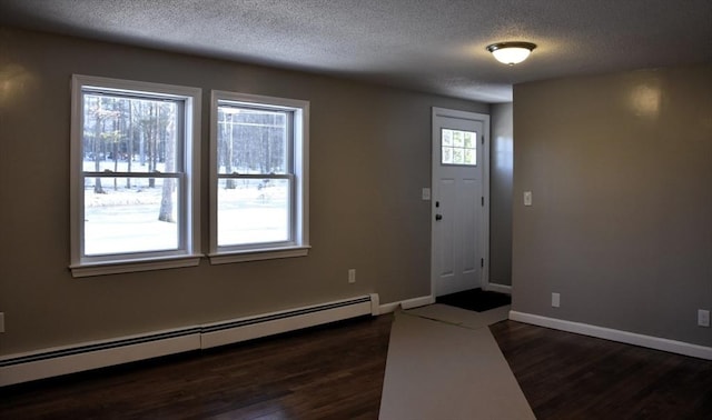 entryway featuring a baseboard heating unit, dark wood-type flooring, a textured ceiling, and baseboards