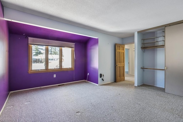 unfurnished bedroom with carpet flooring, a closet, and a textured ceiling