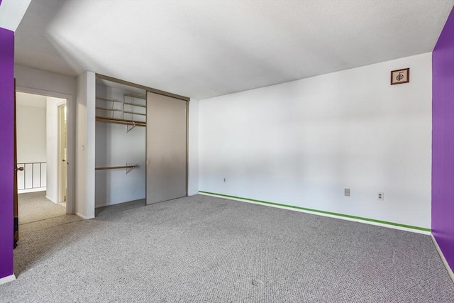 unfurnished bedroom with light carpet and a closet