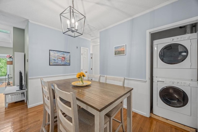 44 Bay Farm Rd Unit 44, Duxbury, MA 02332 - dining area featuring stacked washer / dryer, ornamental molding, light wood-style floors, and a chandelier