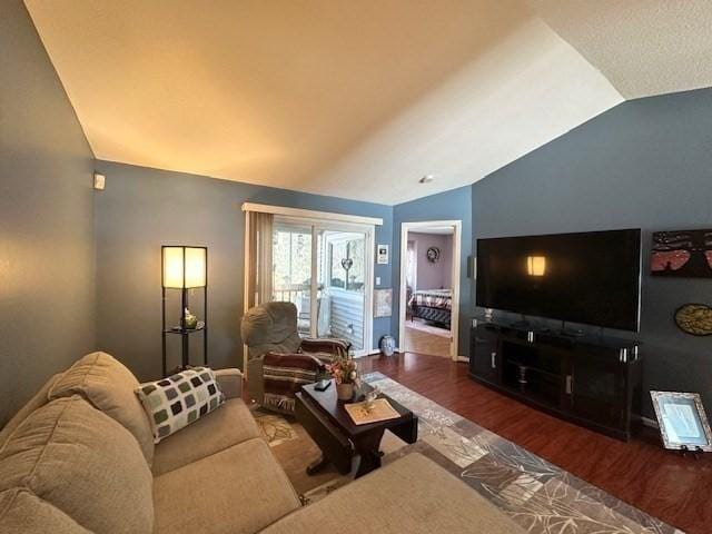 living room featuring dark wood-type flooring and vaulted ceiling