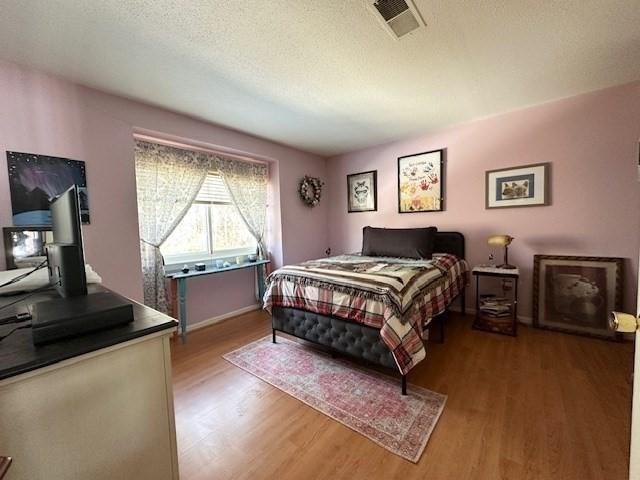 bedroom featuring wood-type flooring and a textured ceiling