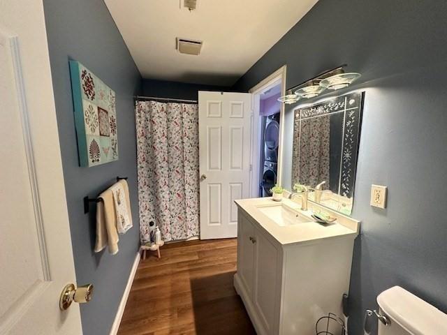 bathroom featuring vanity, hardwood / wood-style floors, and toilet