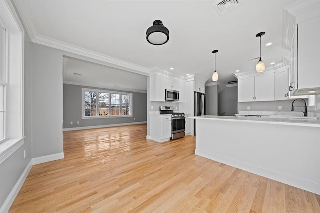 kitchen featuring crown molding, plenty of natural light, white cabinets, and stainless steel appliances