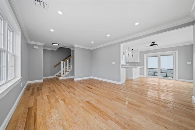 unfurnished living room featuring ornamental molding and light hardwood / wood-style flooring