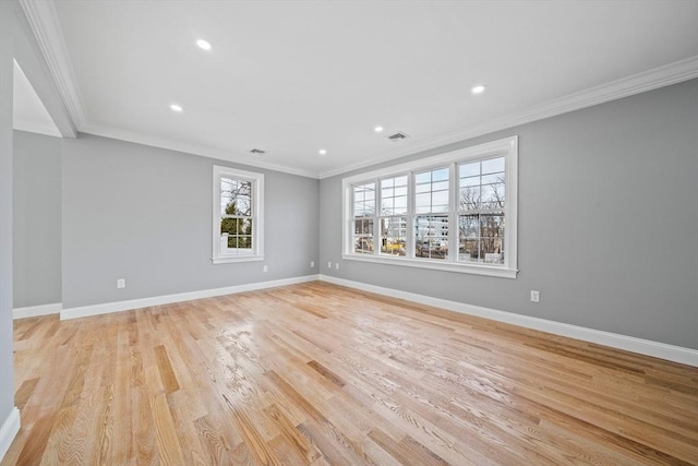 empty room with crown molding and light hardwood / wood-style flooring